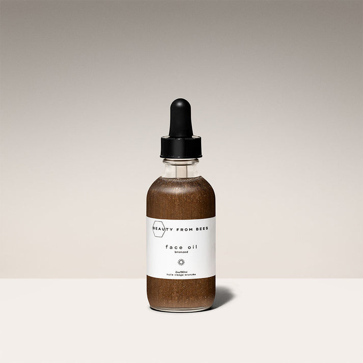 Beauty From Bees bronzed face oil in clear glass dropper bottle with brown shimmer liquid