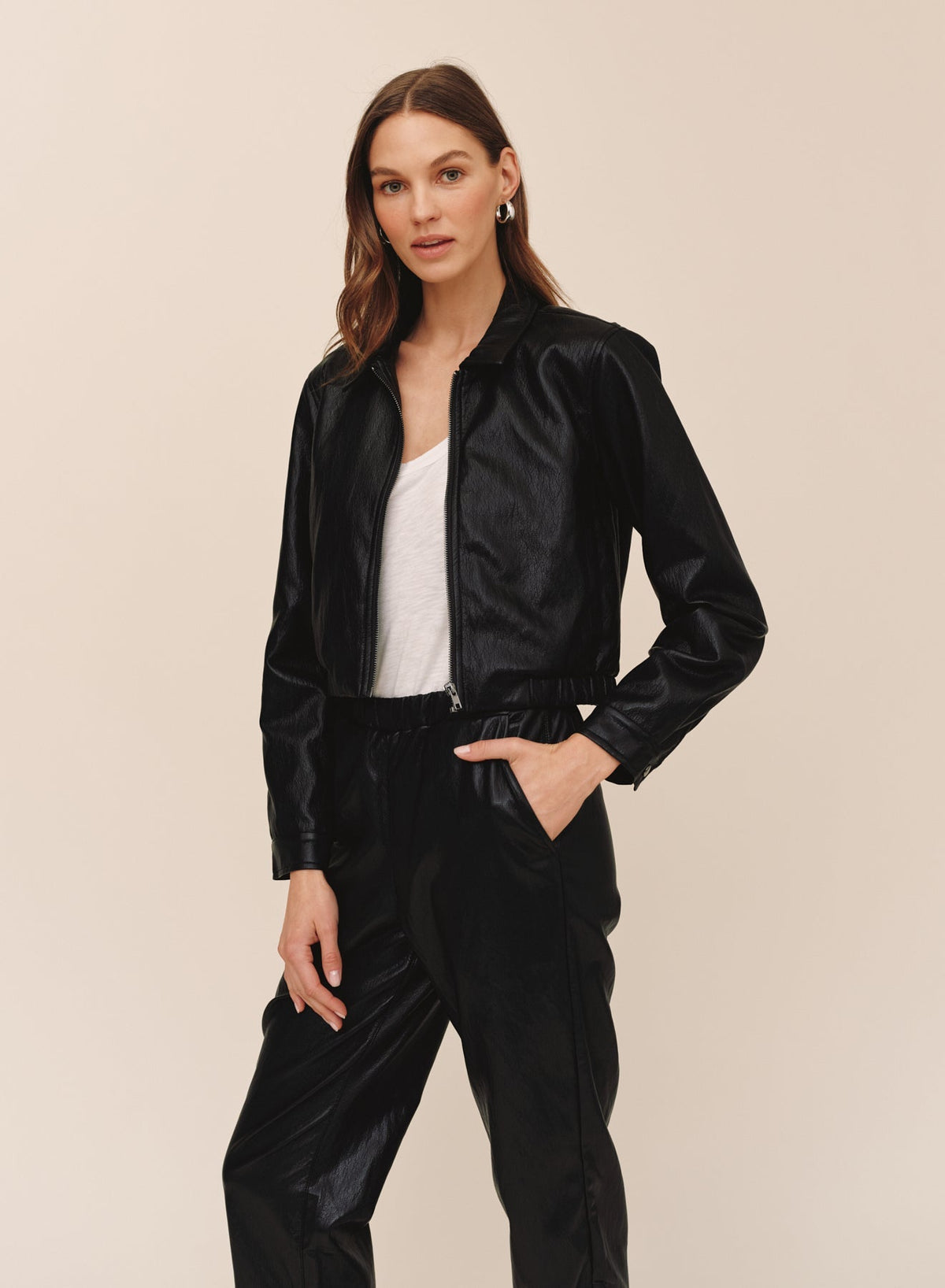 Model wearing Bella Dahl black faux leather crop bomber jacket with matching trousers