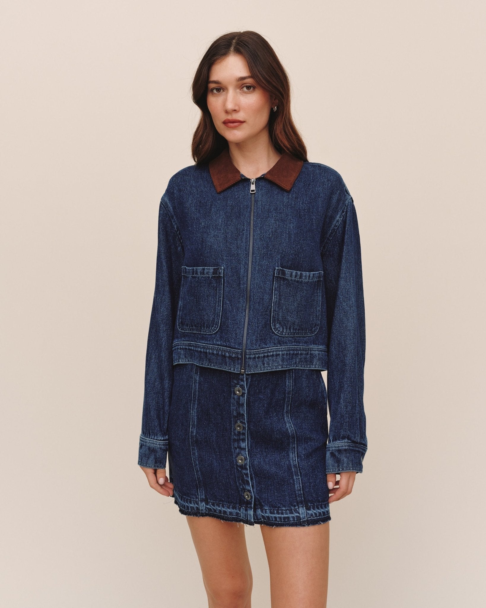 Model wearing Bella Dahl crop zip-up barn jacket in dark rinse wash denim with corduroy collar