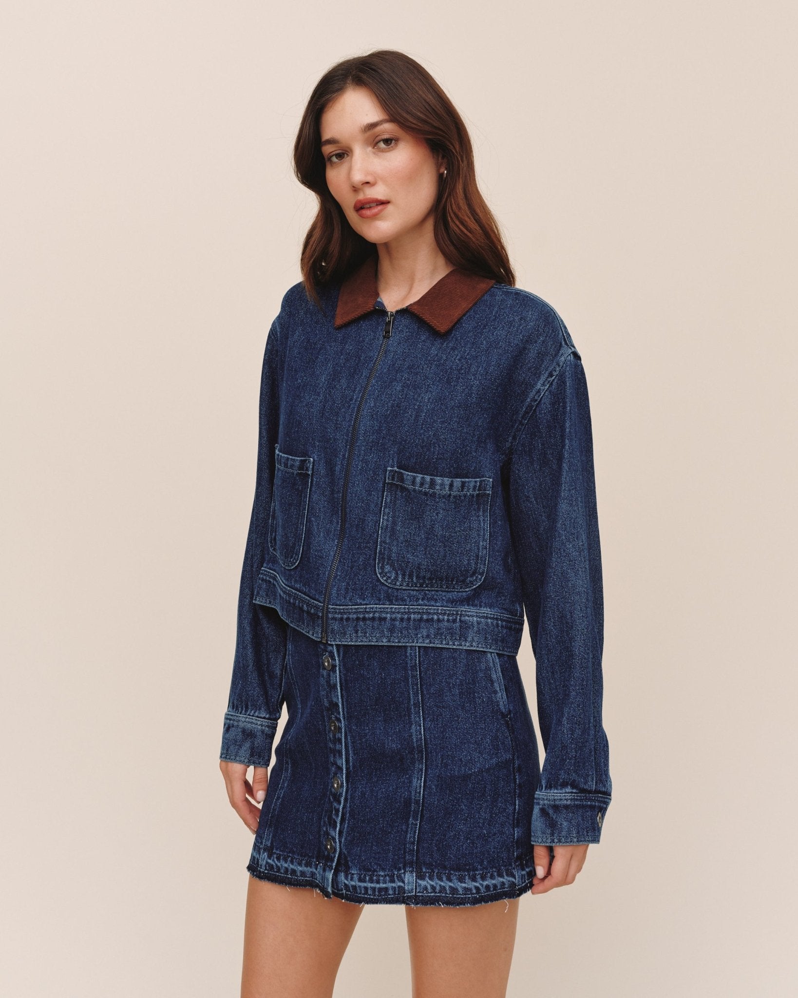 Model wearing Bella Dahl crop zip-up barn jacket in dark rinse wash denim with brown corduroy collar