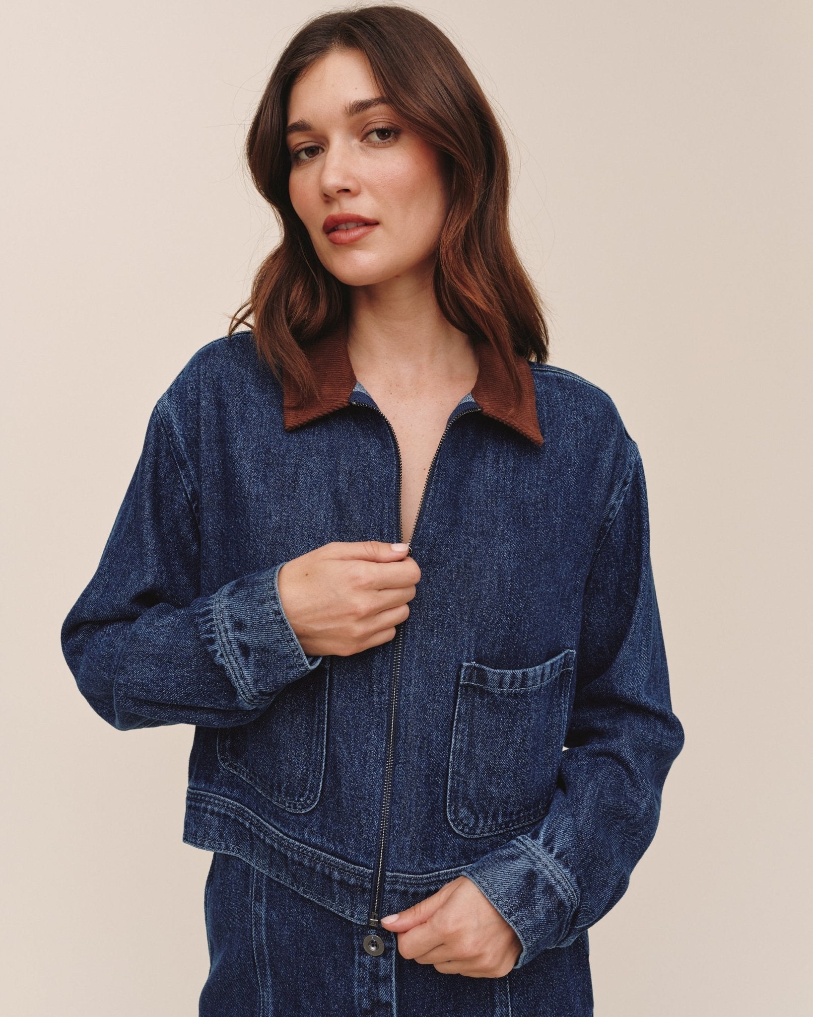 Model wearing Bella Dahl crop zip-up barn jacket in dark rinse denim with corduroy collar
