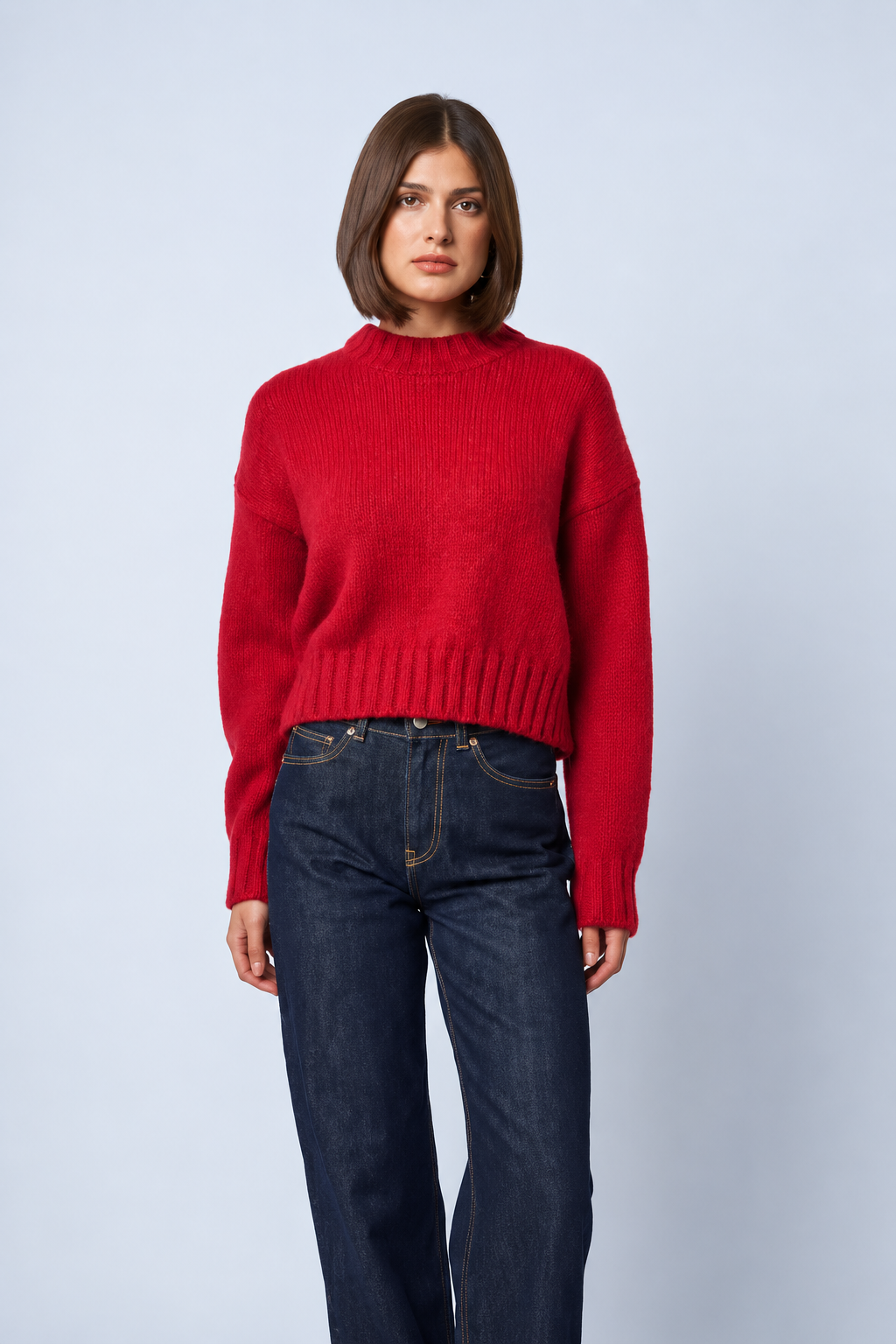 Model wearing Line the Label Hattie red crewneck knit sweater with dark blue jeans