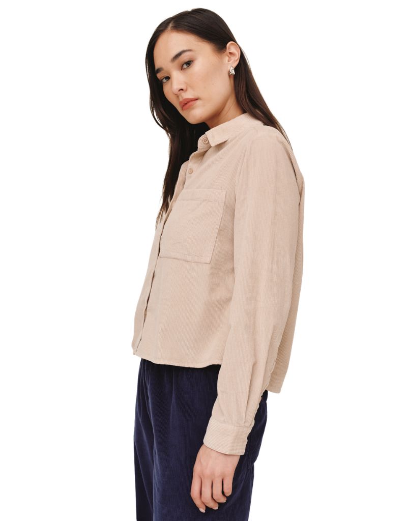 Model wearing a cropped oat corduroy long sleeve shirt with patch pocket, side view