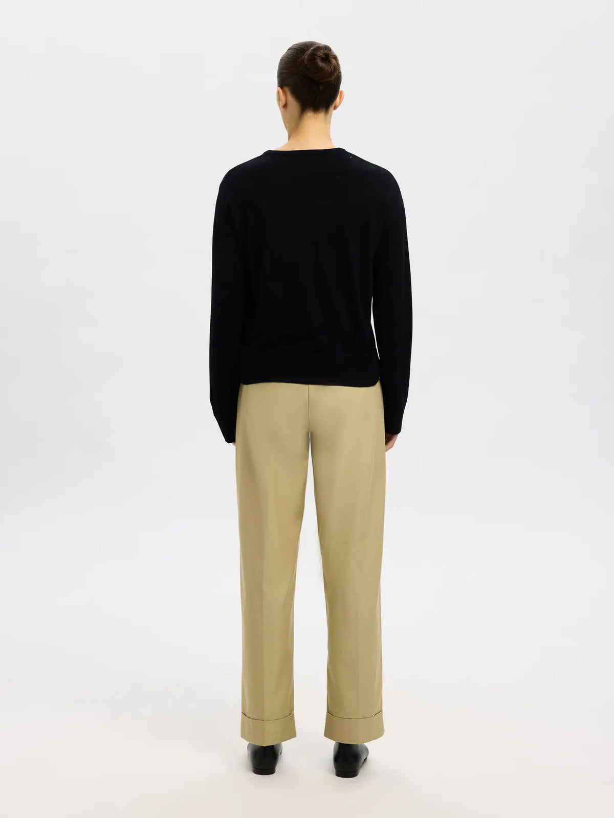 Black merino wool crew-neck sweater with long sleeves, rear view on model