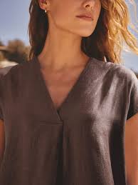 Chocolate brown linen V-neck short sleeve top on woman in sunlight