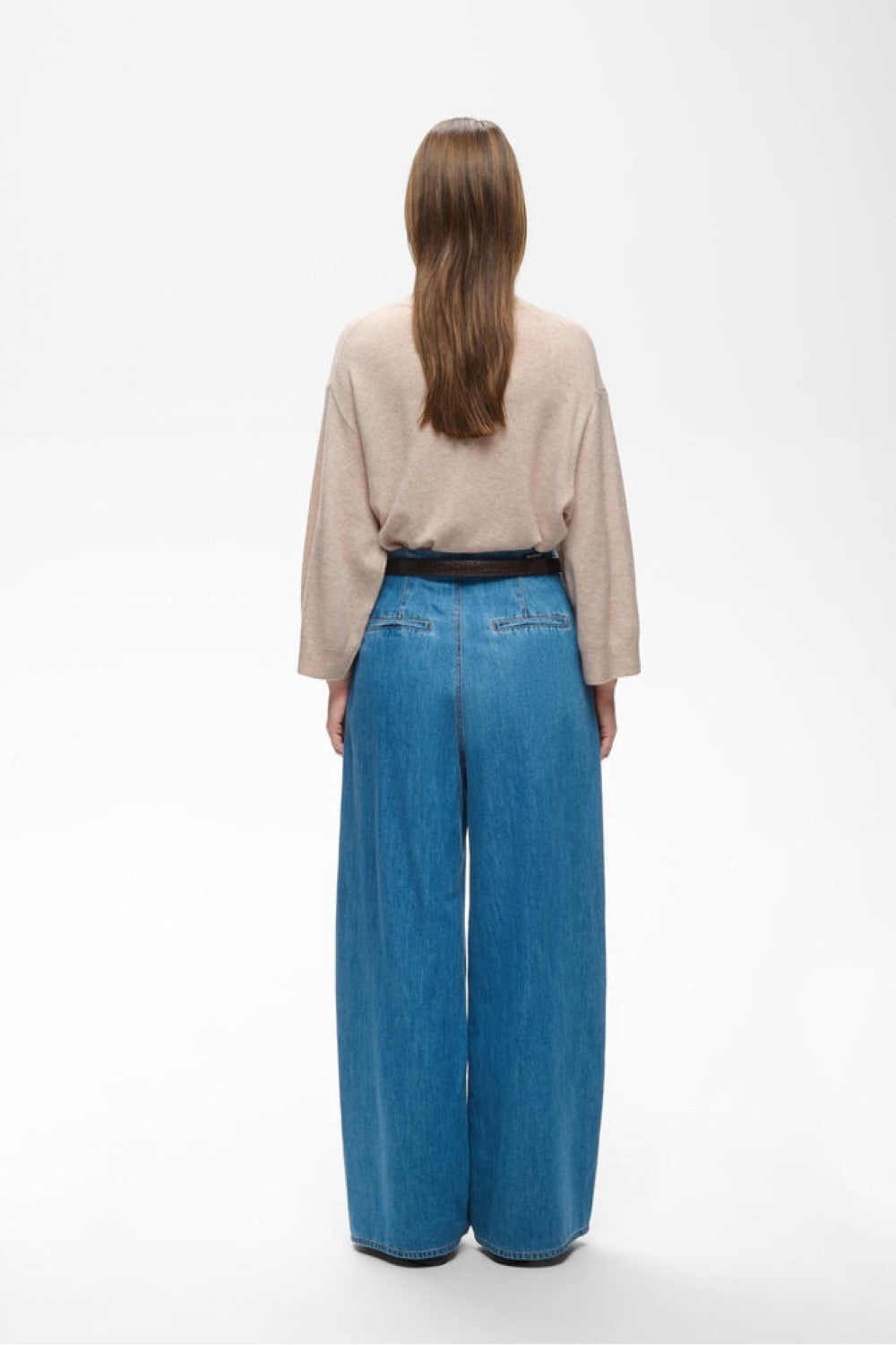Beige highneck knit sweater shown from back, paired with wide-leg blue jeans