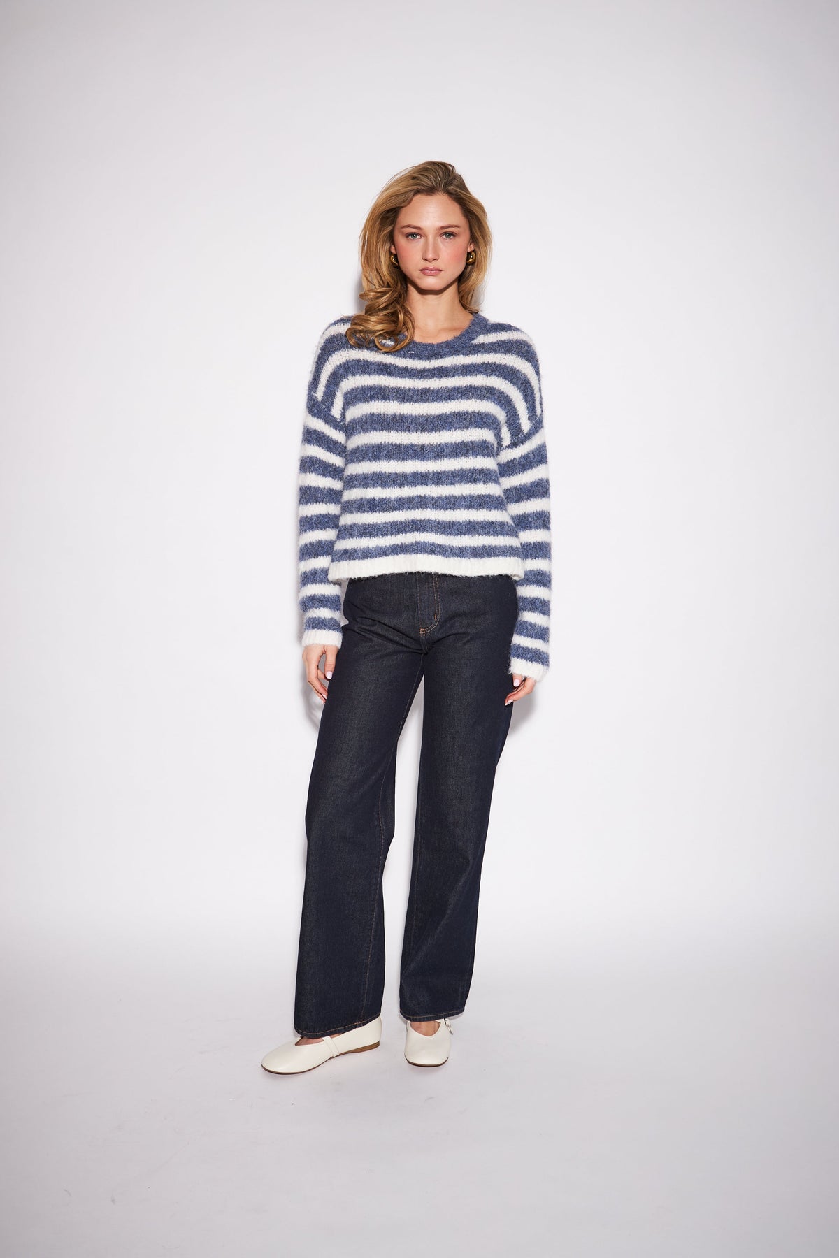 Model wearing John & Jenn Carmen striped fuzzy knit sweater in blue and white denim fade