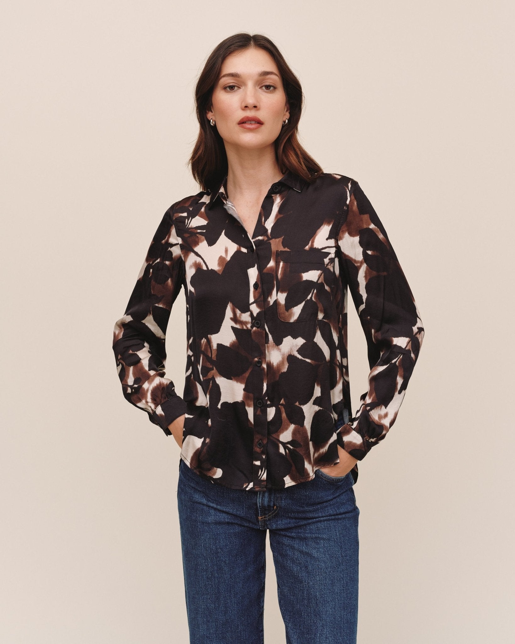 Model wearing Bella Dahl long sleeve button-down shirt in Shadow Floral Print with blue jeans