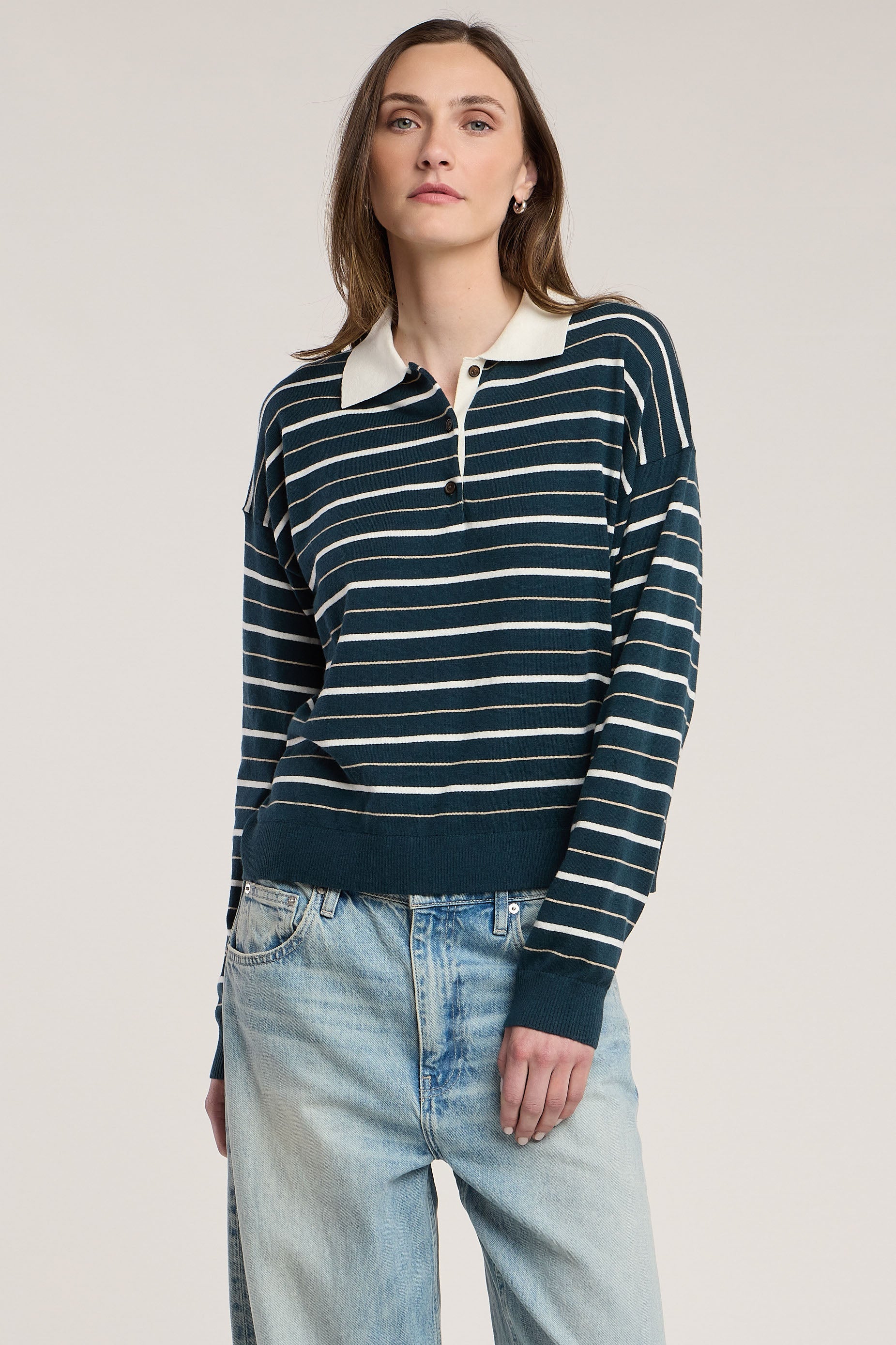 Model wearing Velvet Kaelin07 striped polo sweater in teal and cream with light wash jeans