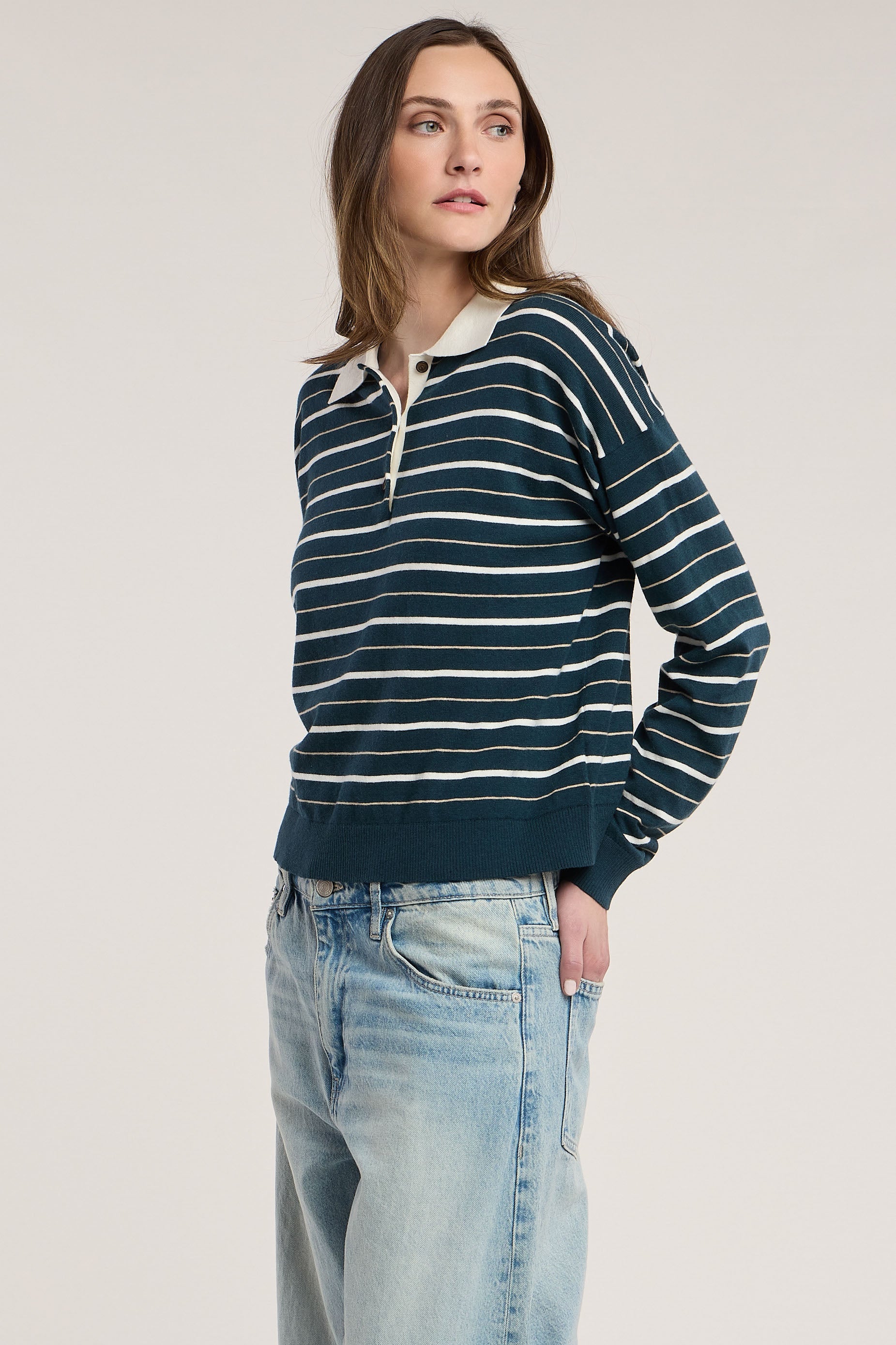 Model wearing Velvet Kaelin07 teal and cream striped polo sweater with light wash jeans