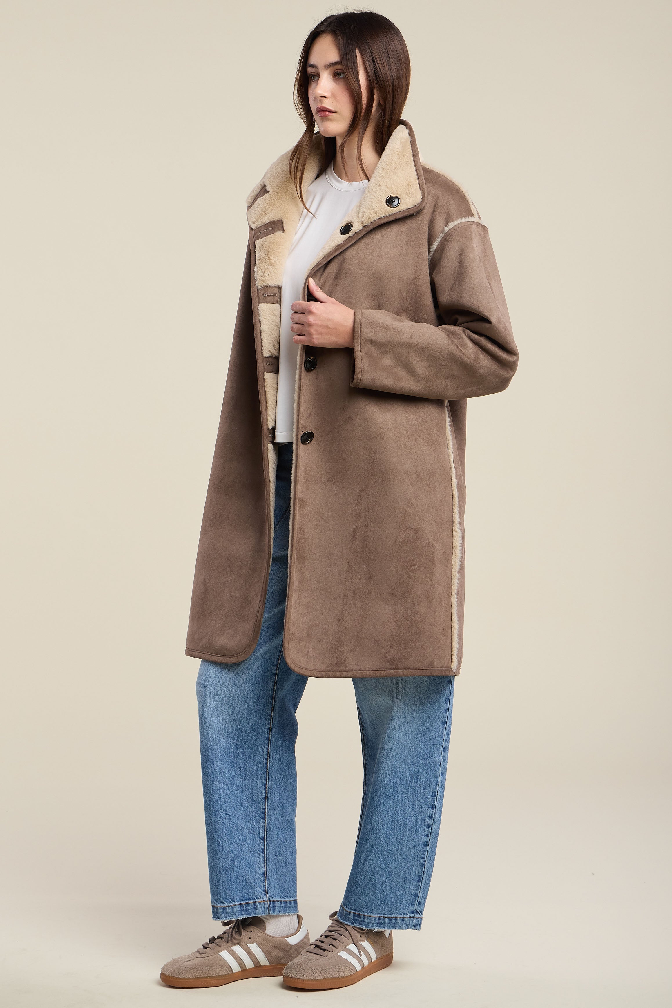 Model wearing Velvet YVES07 faux shearling coat in faded coco with cream lining and blue jeans
