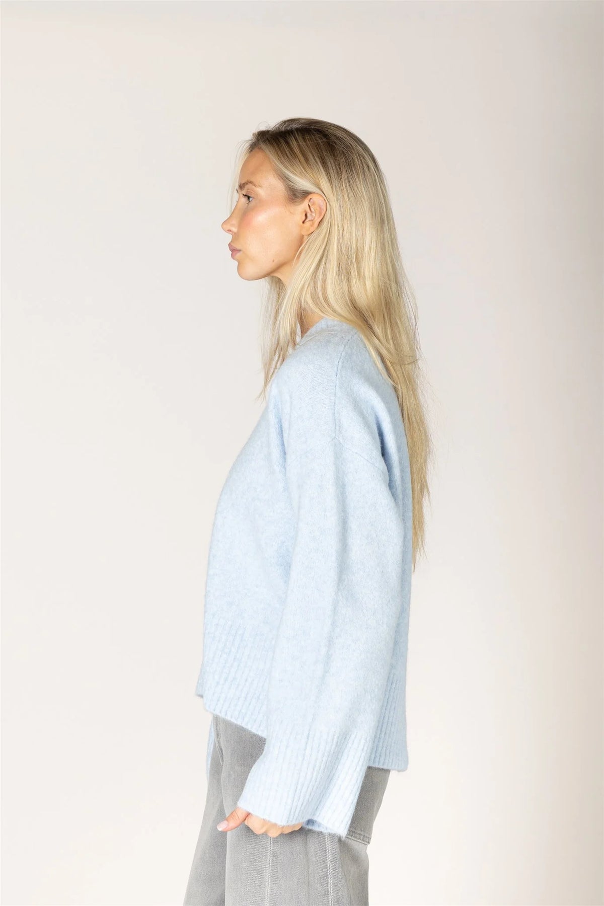 Lyla & Luxe Etta Sweater in baby blue, soft knit with ribbed cuffs, side view.