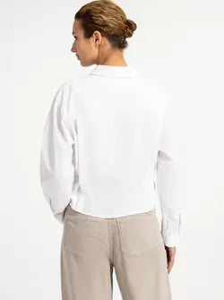 White long-sleeve poplin blouse with button detail, shown from the back