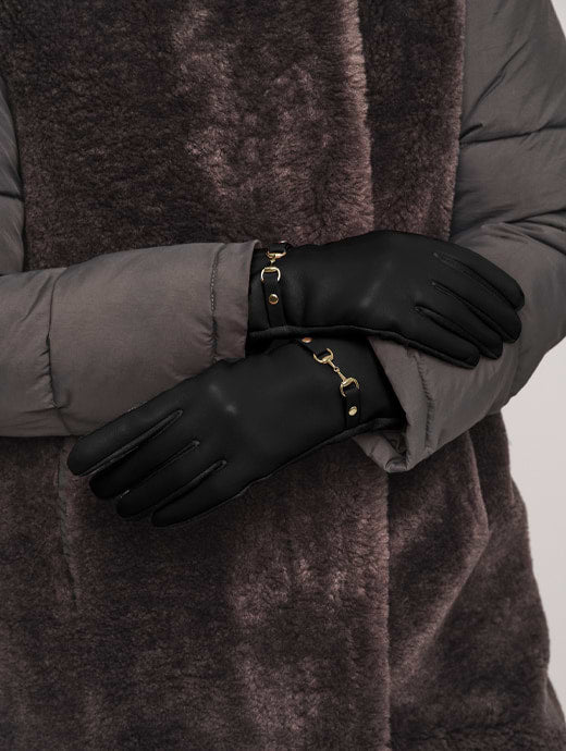 Black leather gloves with gold horsebit hardware detail worn with grey puffer jacket