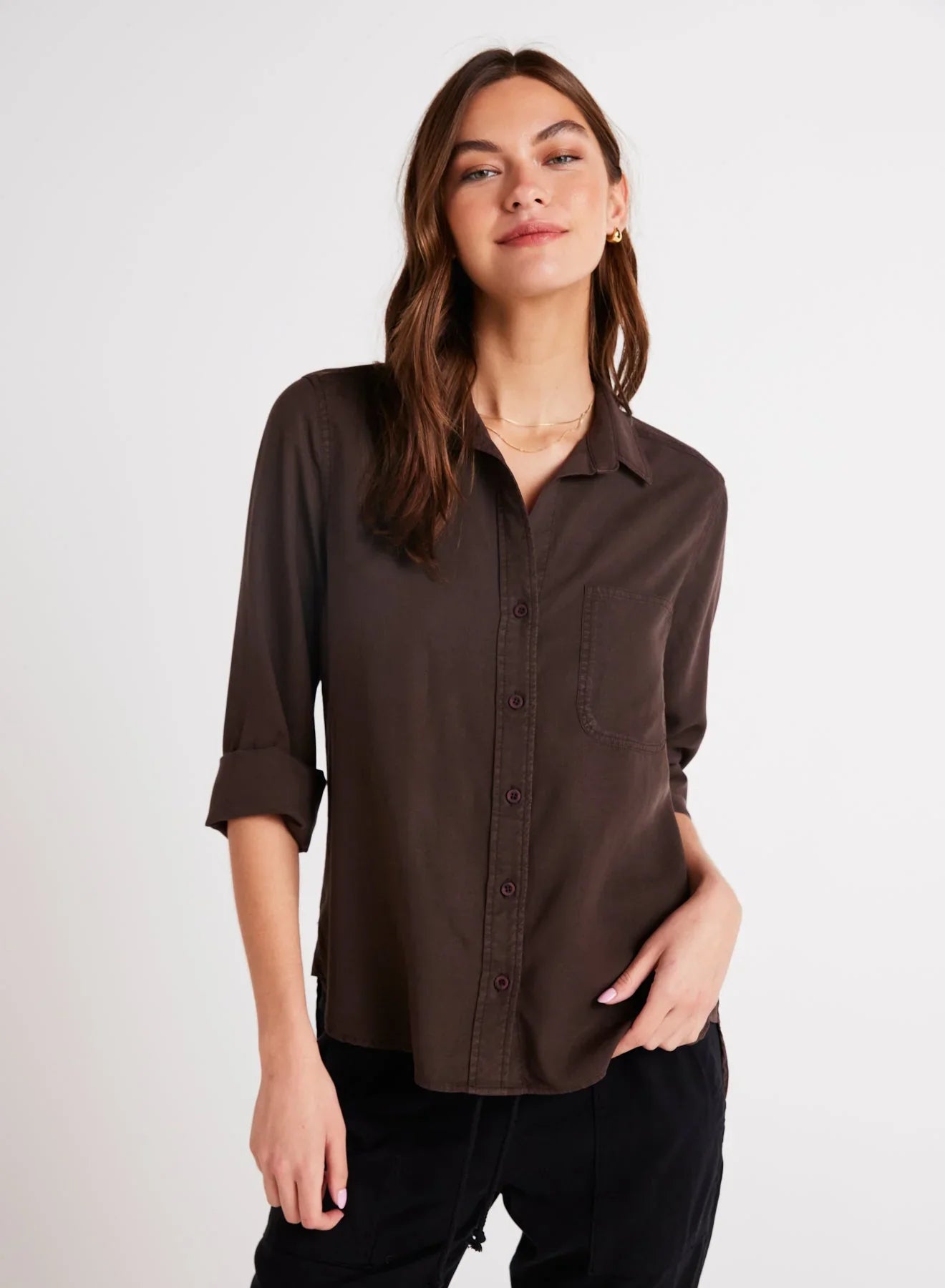 Woman wearing Bella Dahl Shirt Tail Button Down in Dark Chestnut with rolled sleeves