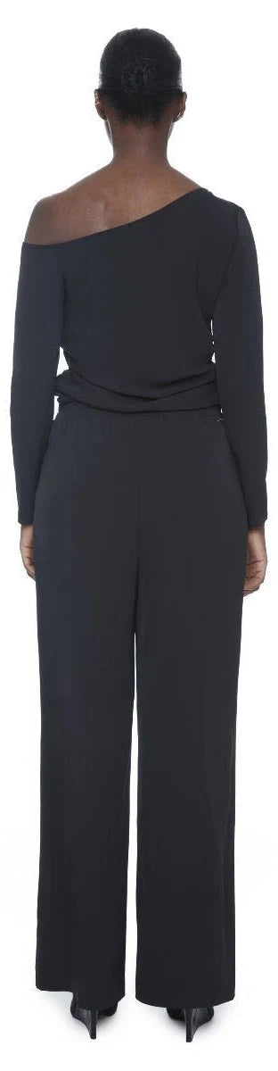Black wide-leg full-length vegan silk pants shown from behind on model