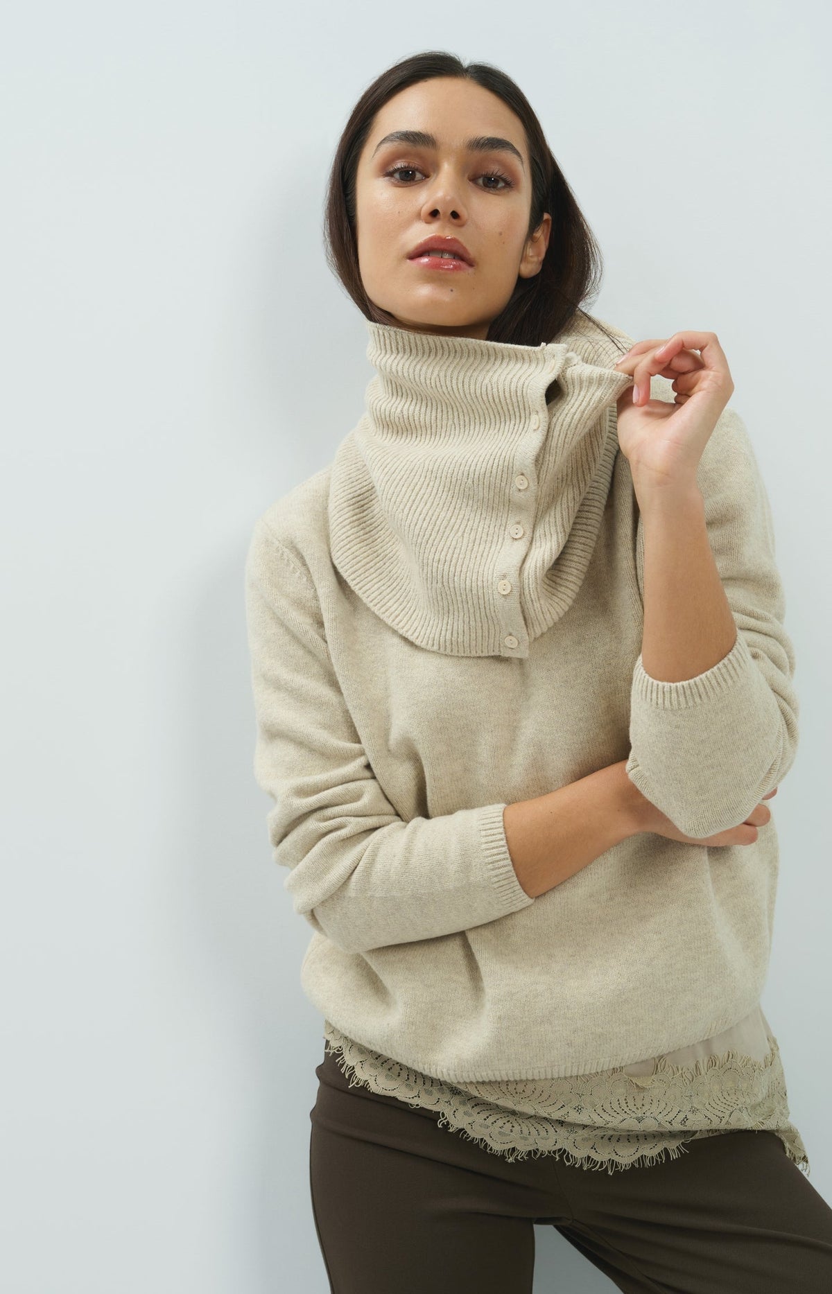 Model wearing YAYA light beige knit sweater with attached ribbed button-detail scarf collar
