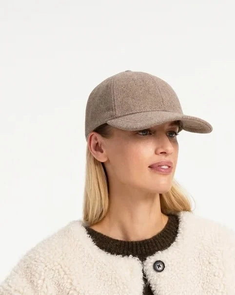 Taupe wool baseball cap with structured brim, worn by blonde woman in shearling jacket